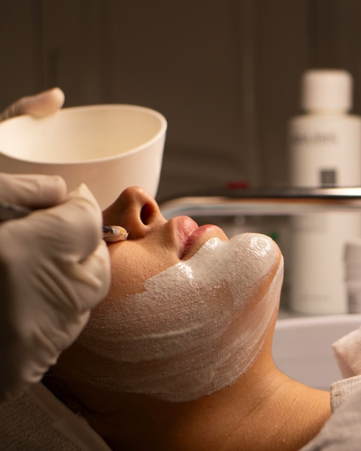 A treatment mask being brushed onto the jaw and neck